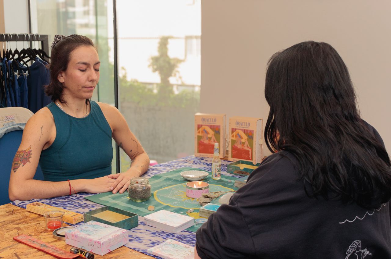 heros-img Two people engaged in an intimate tarot reading session with oracle cards on a decorated table.