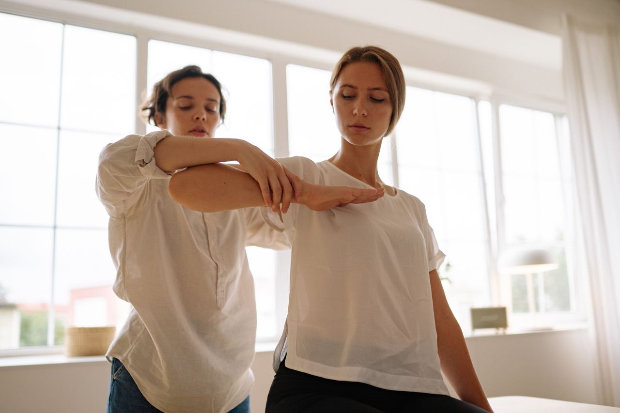 about-us Two women participating in a therapy session indoors, focusing on relaxation and wellness.